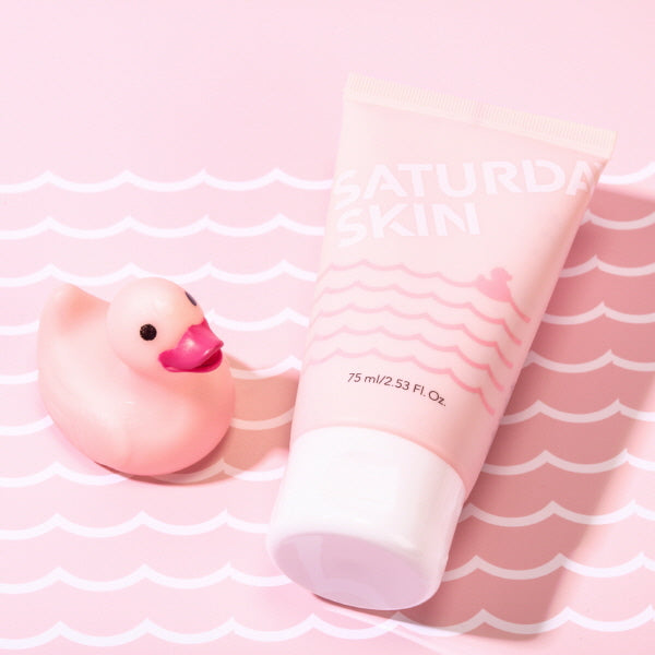 Pink skincare product and rubber duck on a pink and white striped background