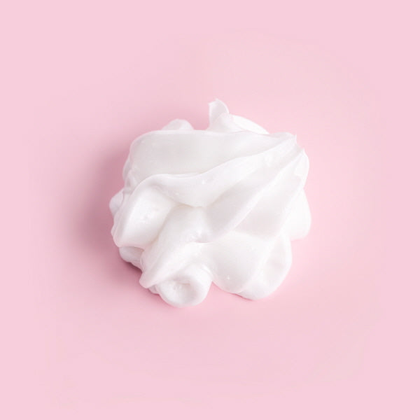 White whipped cream on a pink background