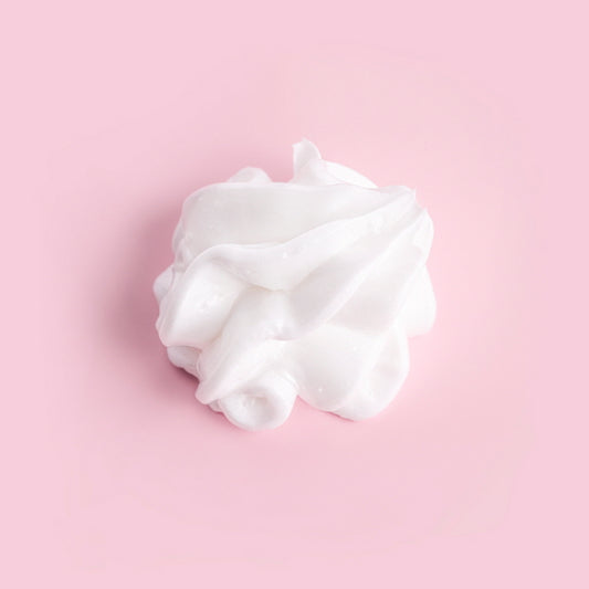 White whipped cream on a pink background