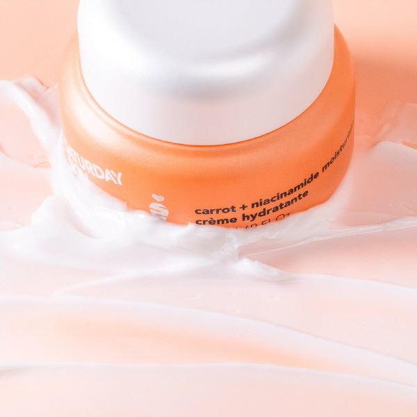 Orange and white jar of cream on a soft pink background