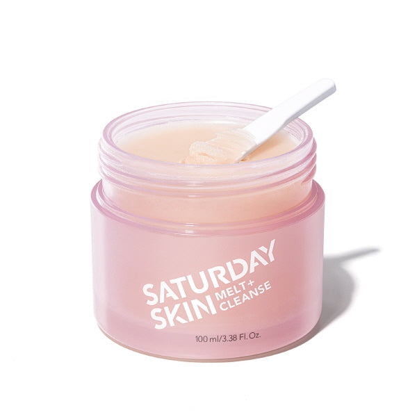 Pink jar of 'Saturday Skin' cream with a spoon on a white background
