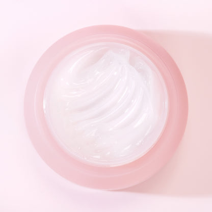 Close-up of a pink contact lens case with a clear lens inside on a light pink background