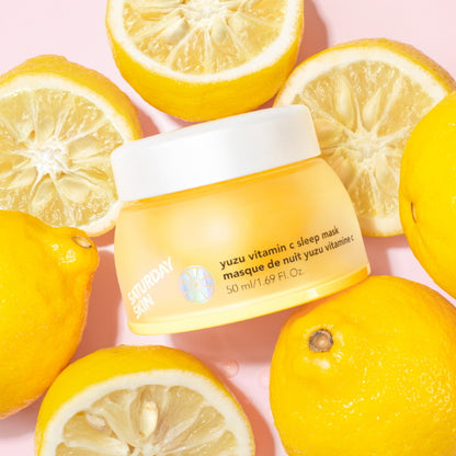 Yuzu vitamin C sleep mask surrounded by sliced lemons on a pink background