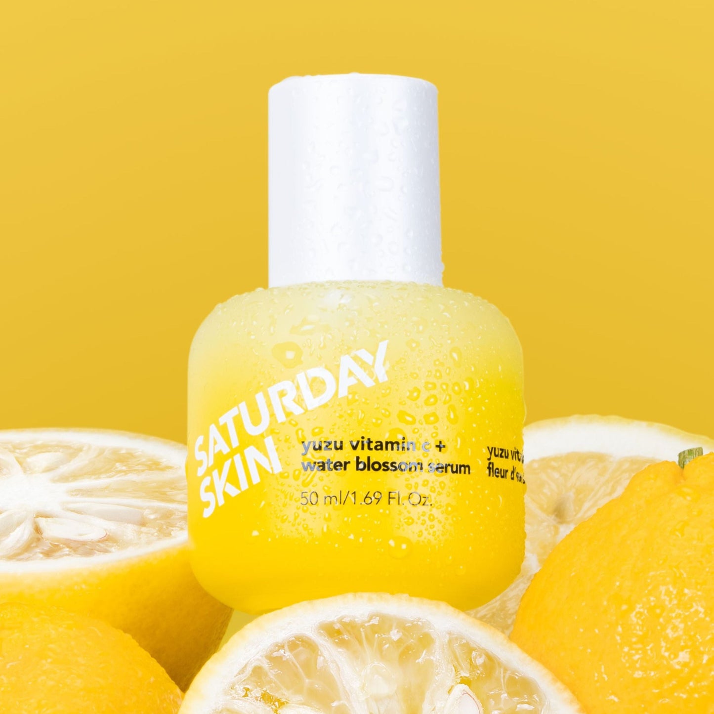 Saturday Skin serum bottle with lemons on a yellow background